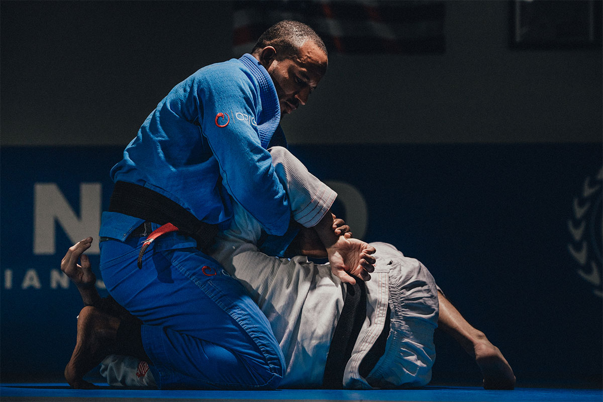 A gi competitor working from top position at a Renzo Gracie academy